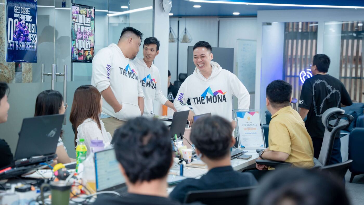 Nhân viên MONA mặc hoodie THE MONA vui mừng trong văn phòng làm việc